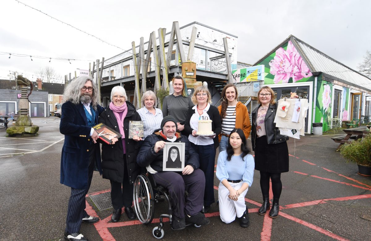 An image of a group of people outside in the courtyard of FarGo Village, celebrating 10 years since opening